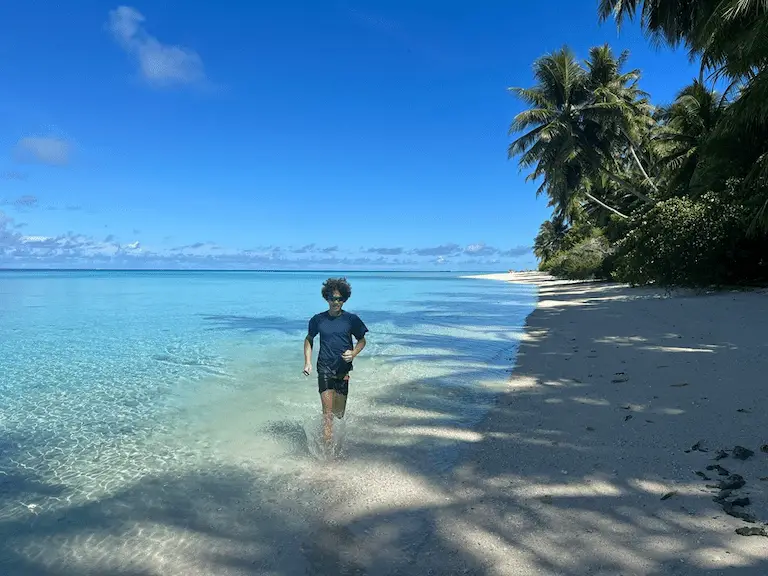 Lone traveler wading in a crystal-clear tropical lagoon in Micronesia